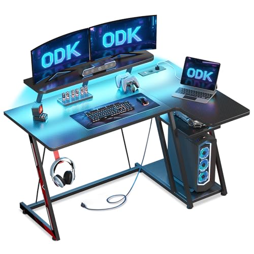 ODK Mesa Gaming esquina com luzes LED e tomadas de energia, mesa Gaming L com suporte para monitor, mesa Gamer com prateleira de armazenamento fibra de carbono preto, 120 x 70 cm